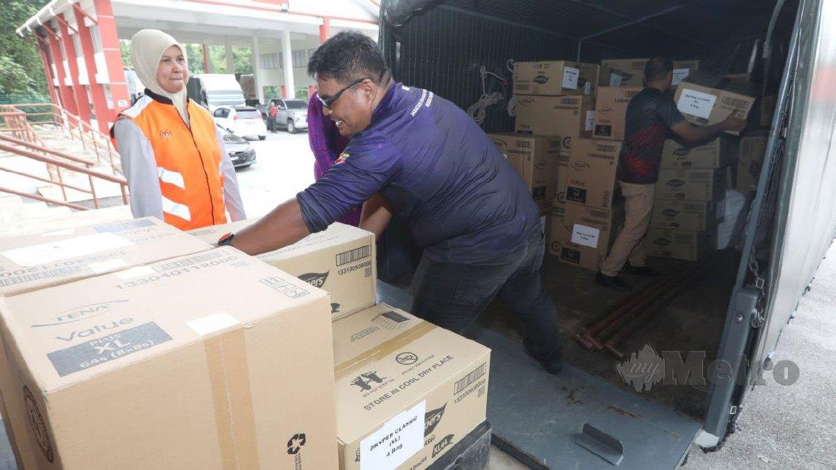 SITI Nor Hasma (kiri) meninjau proses penghantaran barangan bantuan ke pangkalan hadapan di Depoh Simpanan Keperluan Bencana JKM Pahang. FOTO Mohd Rafi Mamat