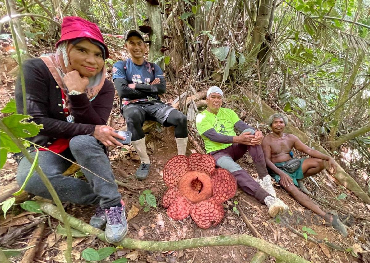 ZAWAWI (tiga kiri) bergambar dengan bunga rafflesia di Hutan Simpan Tembak. FOTO Ahmad Rabiul Zulkifli