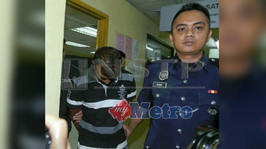 SUSPEK diiringi polis ketika dihadapkan ke mahkamah atas tuduhan membunuh di Mahkamah Majistret Johor Bahru. FOTO Hairul Anuar Abd Rahim