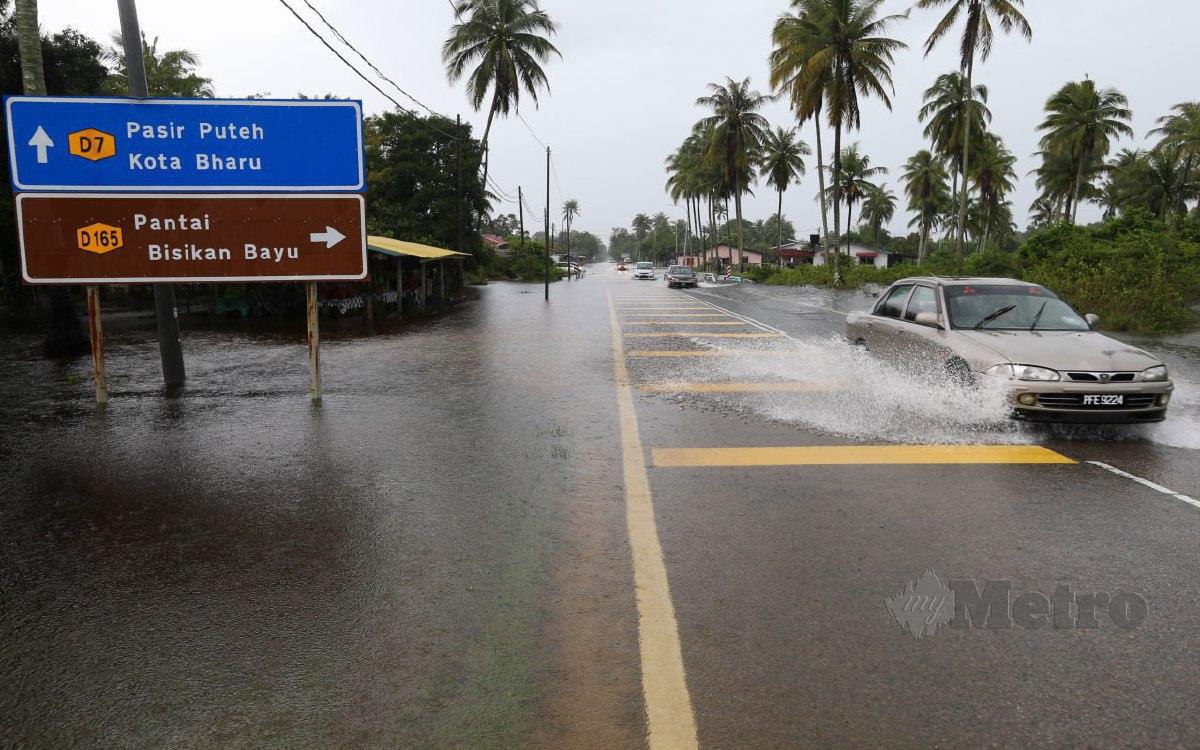 Keadaan banjir di Jalan Kampung Dalam Ru dinaiki air ekoran hujan berterusan sejak semalam ketika tinjauan hari ini. FOTO NIK ABDULLAH NIK OMAR