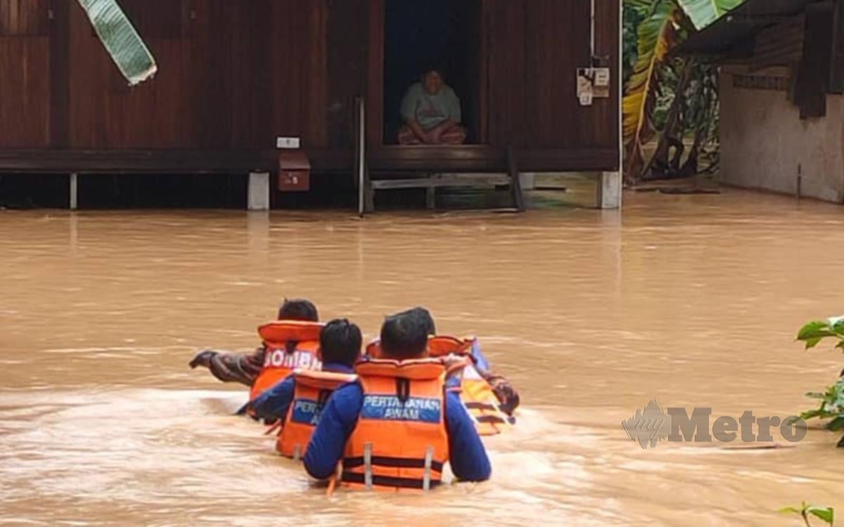 Operasi anggota memindahkan mangsa banjir di kawasan Ijok. FOTO IHSAN APM PERAK
