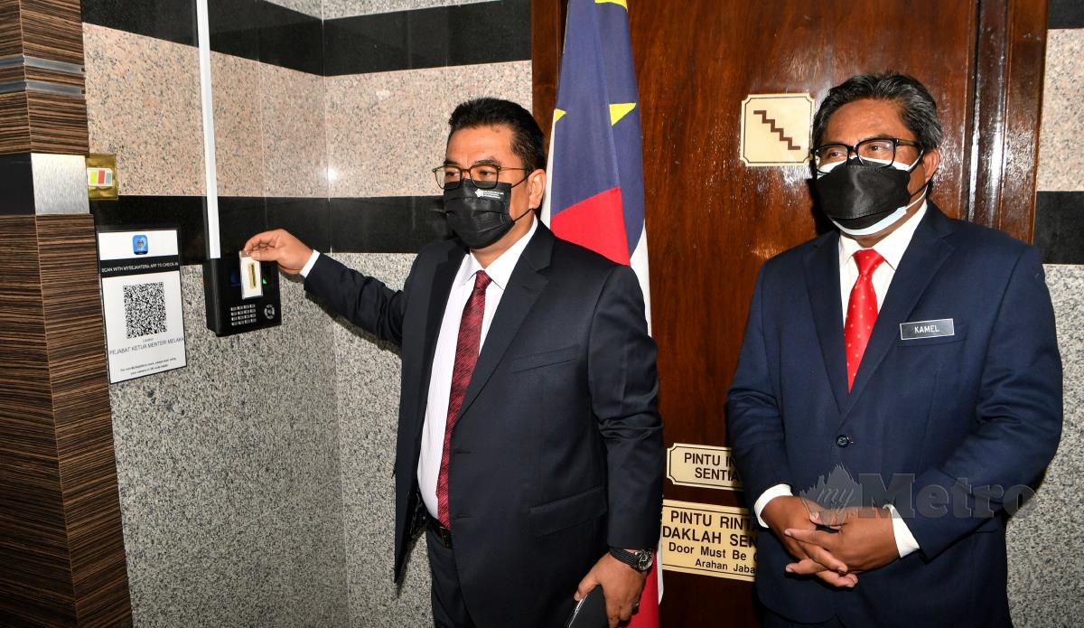 Ketua Menteri Melaka Datuk Seri Sulaiman Md Ali (kiri) mengimbas kad waktu elektronik bagi memulakan tugas pada hari pertama beliau di Pejabat Ketua Menteri di Seri Negeri hari ini. FOTO BERNAMA