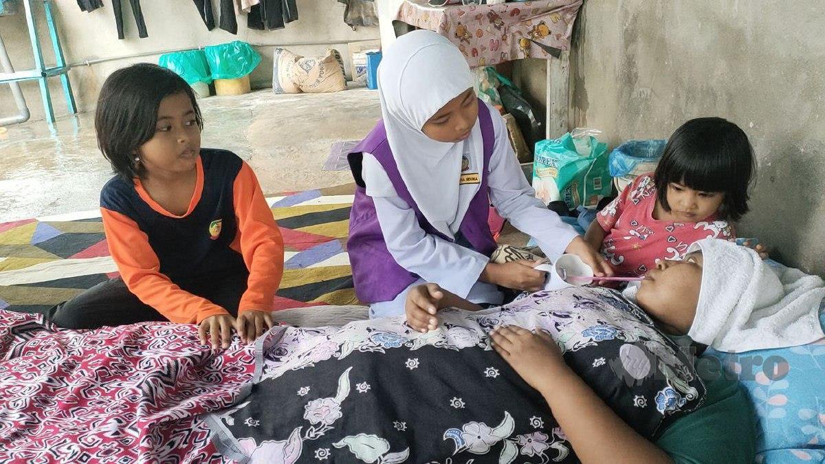 Nur Saffiya Irdina (tengah) menyuapkan susu untuk ibunya, Roliza Md Zain yang menghidap kanser payudara tahap empat bersama dua adiknya,Nur Saffiya Elyana, 8,(kiri) serta Noureen Mikayla, 3, di rumah ibu saudara mereka di Tawar, Kuala Ketil. FOTO ZULIATY ZULKIFFLI