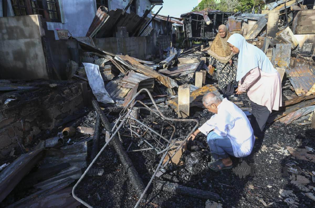 Warga Penghuni pondok  melihat keadaan rumahnya yang hangus membabitkan 10 buah rumah sewa di Kampung Terusan Limbat musnah dalam kebakaran petang semalam. FOTO NIK ABDULLAH NIK OMAR