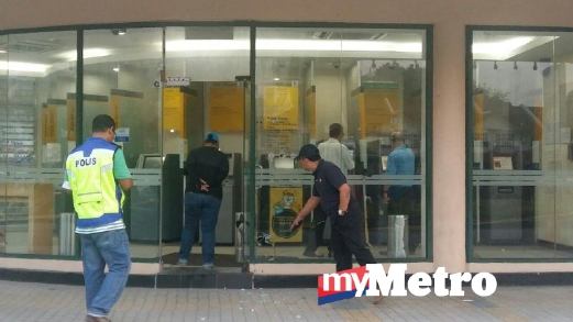 ANGGOTA polis memeriksa keadaan mesin ATM. FOTO Mohd Hilmi Mahmud
