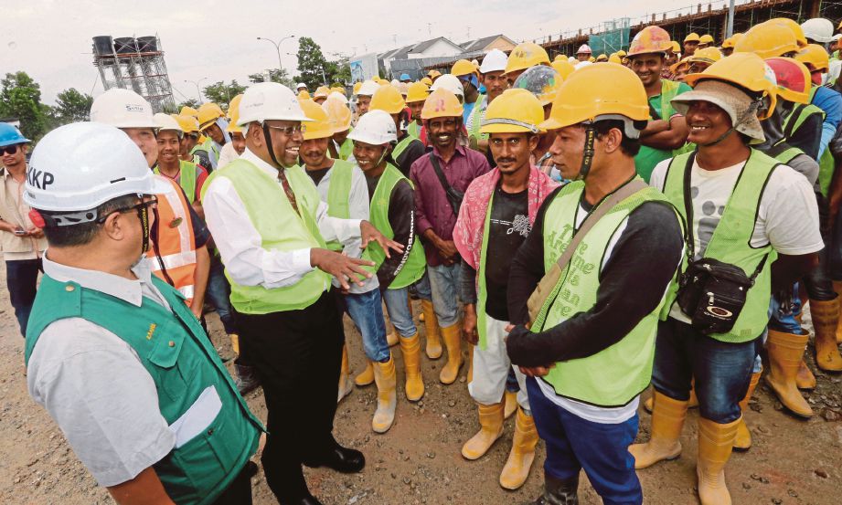 DR S Ramakrishnan (tiga dari kiri) bersama Saiful (kiri) bertemu  pekerja binaan selepas merasmikan majlis Pelancaran Program WAFEW 2018 Peringkat Johor di Taman Setia Tropika, semalam.