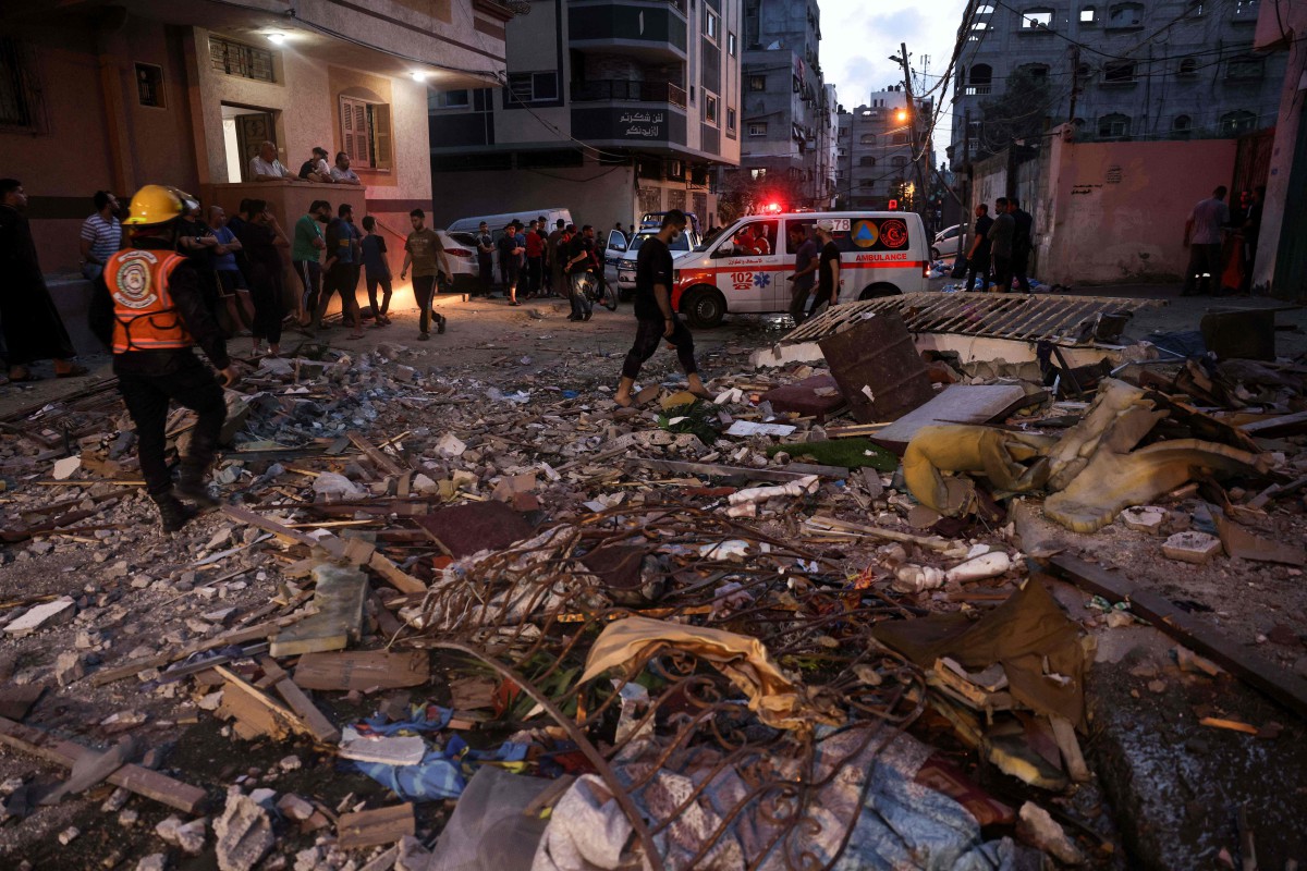 PASUKAN pertahanan awam Israel memeriksa runtuhan apartmen di Gaza. FOTO AFP 