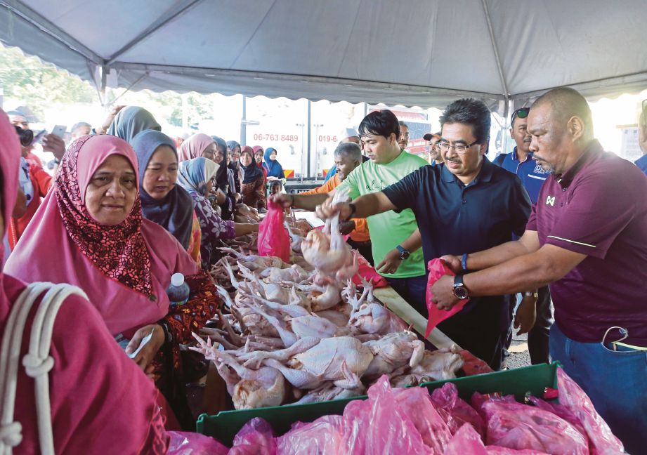  JOHARI (tengah) melawat gerai jualan barangan basah pada  Program Jualan Sentuhan Rakyat di PPR Jalan Jelatek.