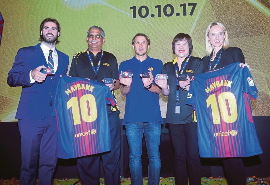 RAVINTHARAN (dua dari kiri) bersama  Zabala (tengah) dan Asensi (kiri) pada majlis pelancaran kad kredit Maybank FC Barcelona Visa Signature dan kad debit Visa Debit Platinum, semalam.
