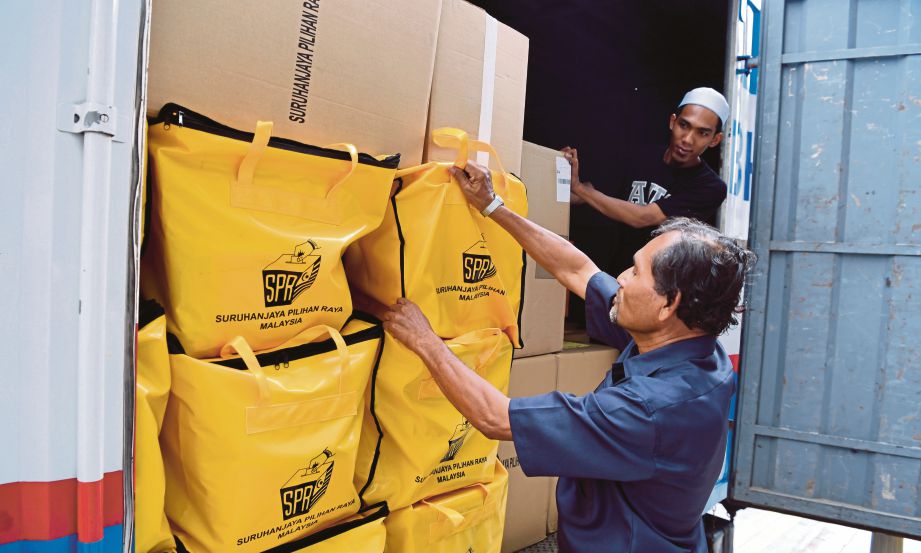 PETUGAS pejabat Daerah Kepala Batas memunggah barang keperluan untuk PRU14 dari pejabat SPR di Jalan Pengkalan Weld, semalam.