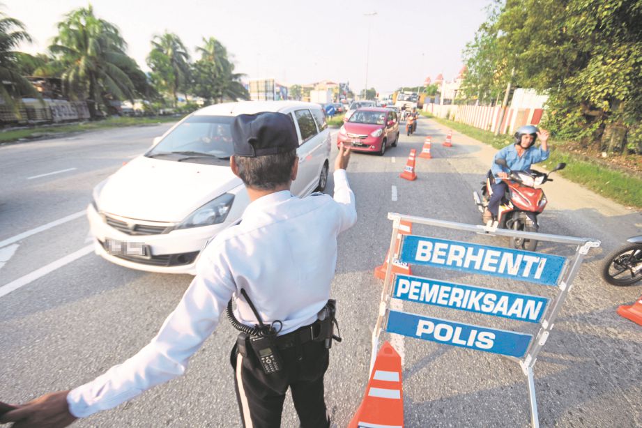 ANGGOTA polis trafik melakukan sekatan di Jalan Banting-Pandamaran, semalam. 