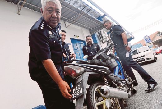 SHAIKH Adzis (kiri) menunjukkan sebuah motosikal bernombor pendaftaran palsu yang dirampas. 