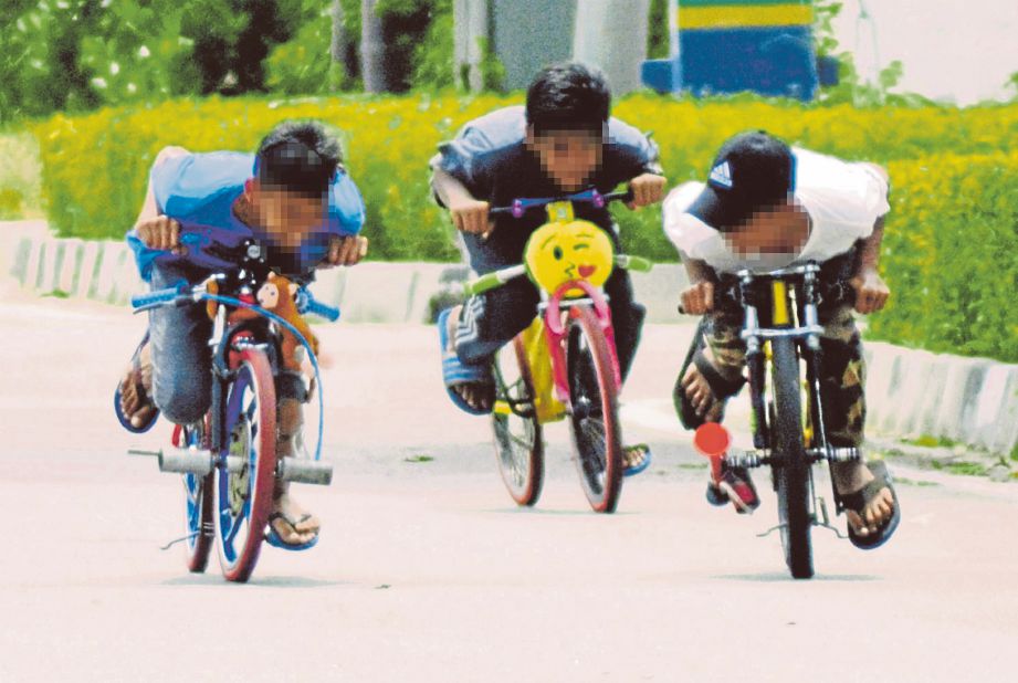 TIGA ahli geng basikal lajak berlumba sesama sendiri di jalan masuk ke Taman Rekreasi Pantai Robina, Teluk Air Tawar, Butterworth.