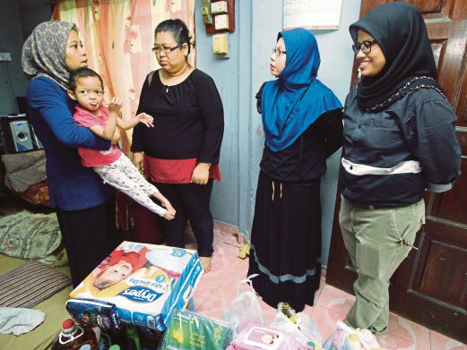 MuliatI (kiri) bersama anaknya, Nur Qaseh Amanda menerima kunjungan kakitangan pasar raya Econsave.