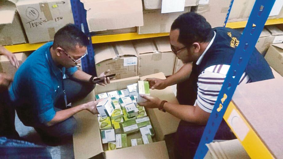 PEGAWAI KKM memeriksa produk beracun  di sebuah gudang di Rawang, Selangor, semalam. 