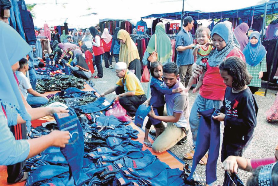 PENGUNJUNG memilih pelbagai pakaian di Pasar  Borong Pekan sebagai persiapan menyambut Aidilfitri.