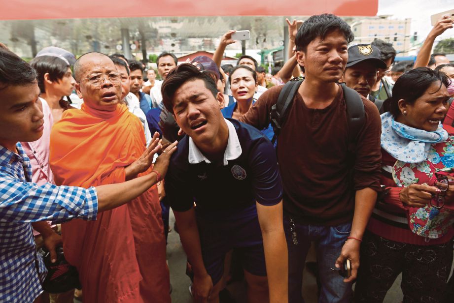 ORANG ramai memujuk anggota keluarga Kem Ley ketika mengarak mayat mangsa.