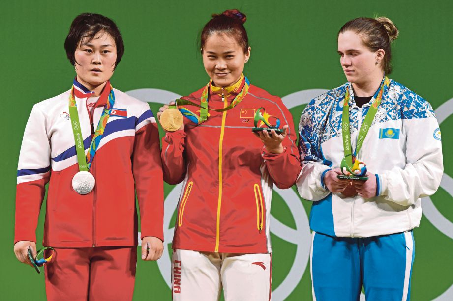 DENG Wei (tengah) ceria memperaga emas pertamanya di Olimpik. 