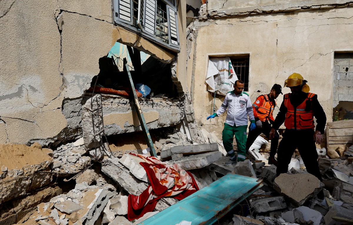 PASUKAN penyelamat Palestin memeriksa runtuhan rumah komander Ahmed Abu Daqqa yang dimusnahkan Israel di Gaza, hari ini. FOTO Reuters.