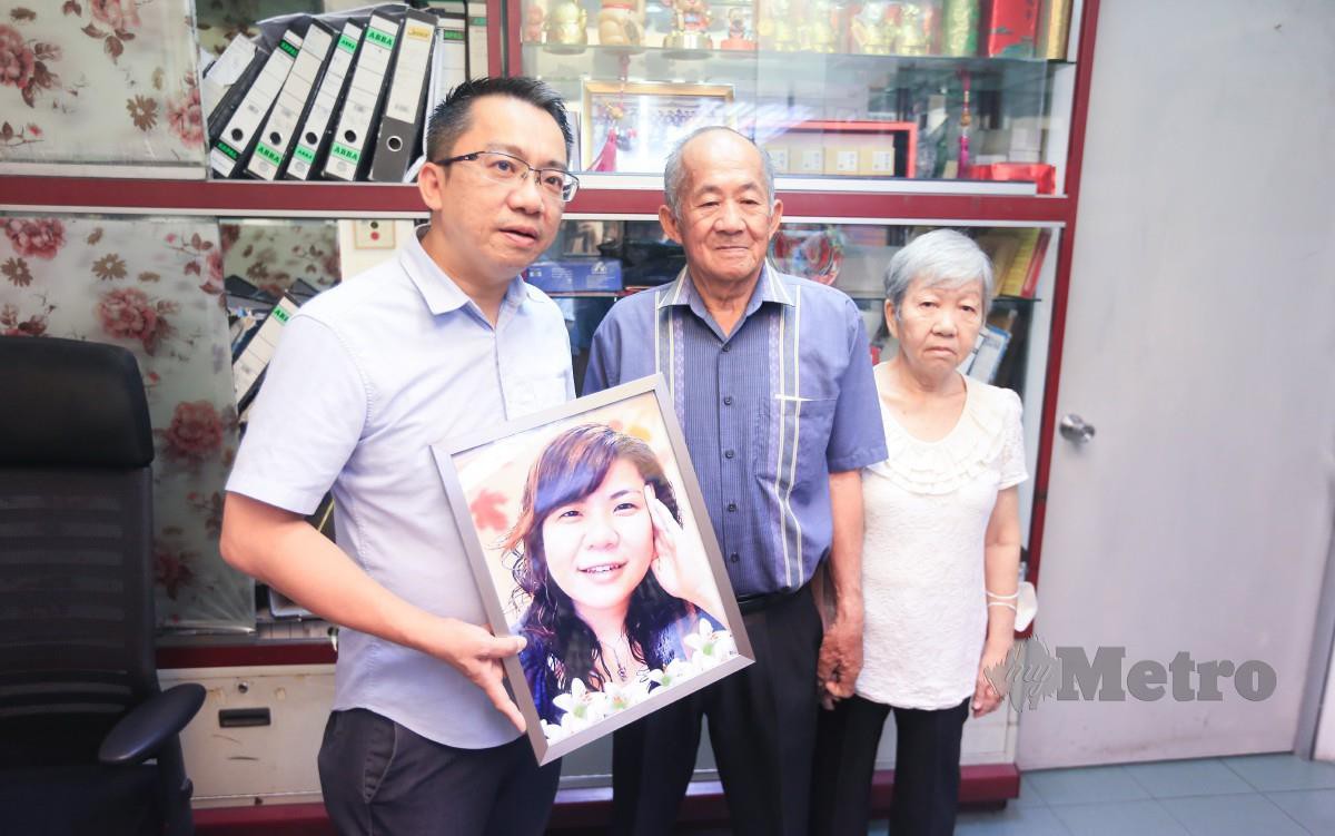 LAI Choon Seng memegang gambar mendiang Lai Lee Yin ditemani ibu bapanya. FOTO Genes Gulitah.