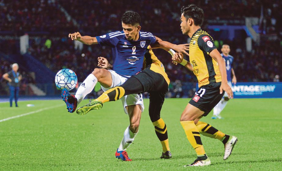 PEMAIN Johor DT Azammuddin Akil (kiri) cuba melepasi kawalan dua pemain Perak.