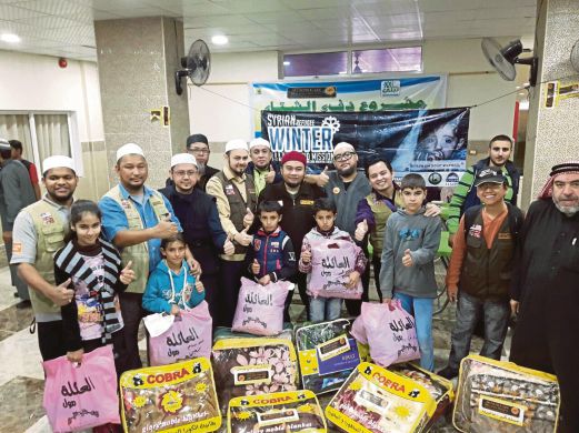 KANAK-KANAK pelarian Syria menerima sumbangan daripada Muslim Care Malaysia.