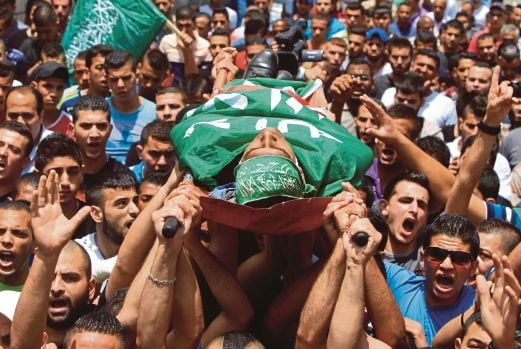 JENAZAH Ezzedine yang diselubung dengan bendera Hamas diusung untuk dikebumikan di Jenin, Tebing Barat, semalam.  
