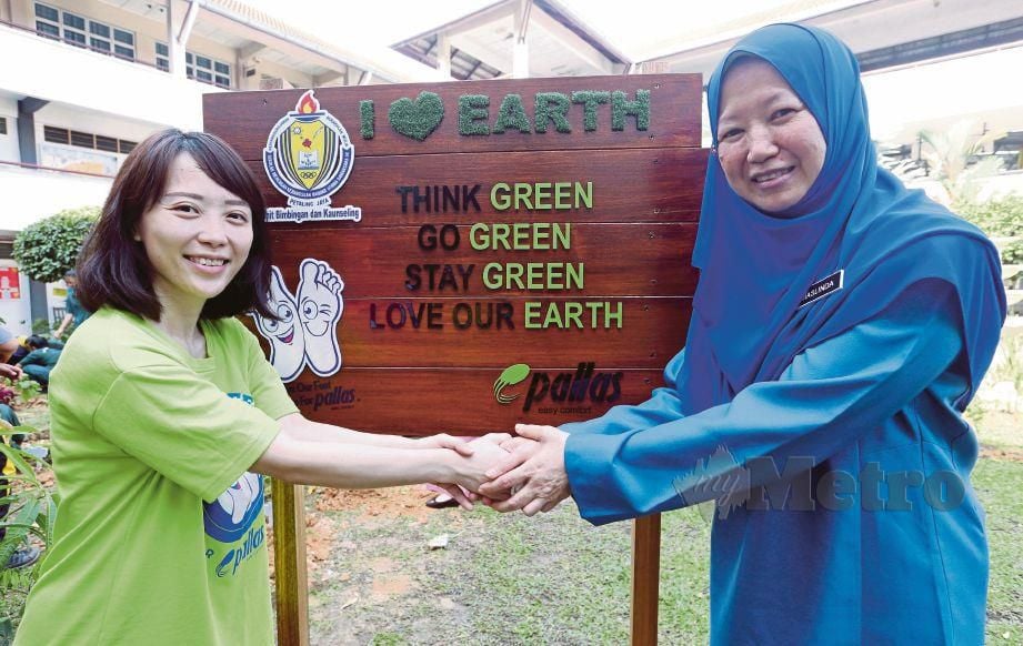 MASLINDA  (kanan)  dan   Jo Yee melakukan gimik kempen  di tapak projek Go Green with Pallas. 