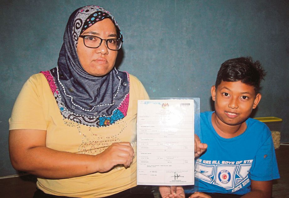  Sharifah Suhaila  bersama anak angkatnya, Muhd Amirul Haziq menunjukkan Sijil Pendaftaran Kelahirannya. 