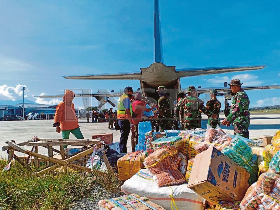 PESERTA misi, mangsa bencana dan tentera bekerjasama mengeluarkan barang bantuan yang tiba di Lapangan Terbang Sis Al Jufri, Palu daripada pesawat C-130 Hercules milik Angkatan Udara (TNI-AU). 