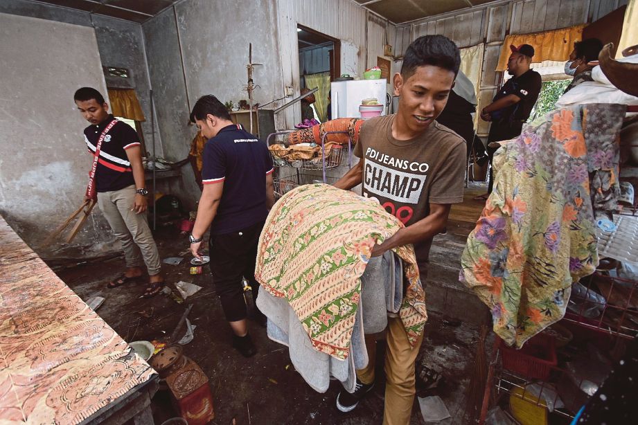 SUKARELAWAN dan pelajar UiTM gotong-royong membersih rumah asnaf dan miskin pada Program ProjeKasih UiTM Shah Alam di Kampung Telok Menegun, Klang.