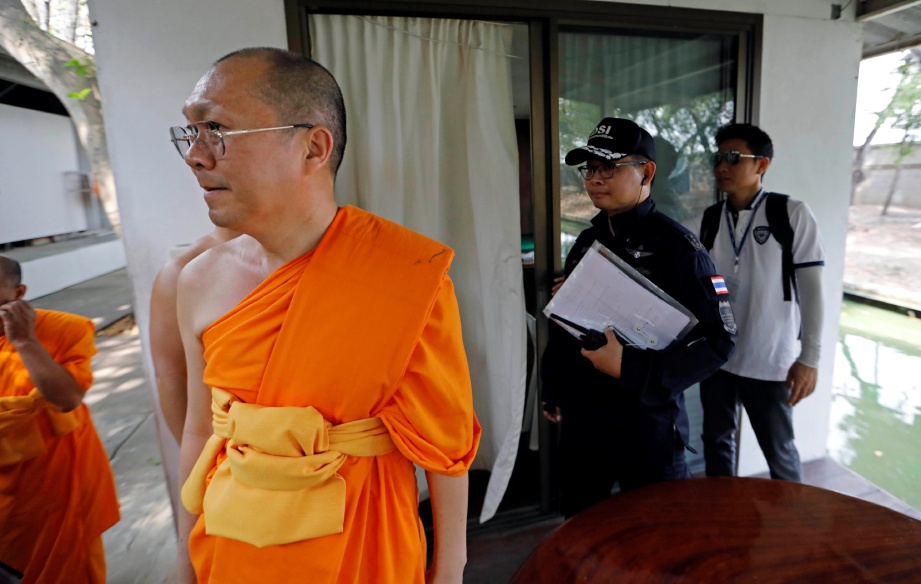 SAMI di kuil Wat Phra Dhammakaya mengiringi anggota pegawai kanan polis memeriksa kuil berkenaan, semalam.  - Reuters