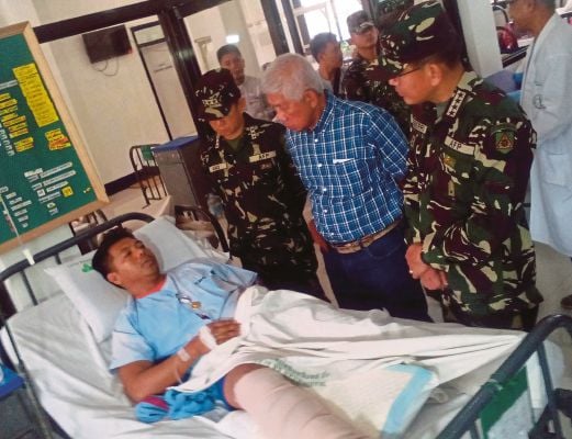 Setiausaha Pertahanan Filipina Voltaire Gazmin (dua dari kanan) dan panglima tentera,  Jeneral Hernando Iriberri (kanan) melawat seorang askar yang cedera di hospital tentera di Zamboanga, semalam. 