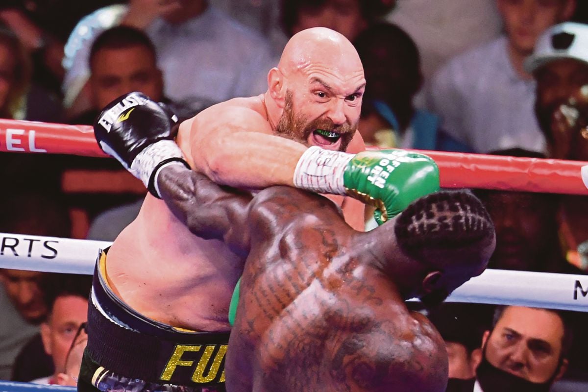 Juara heavyweight WBC Tyson Fury (kiri) berdepan Deontay Wilder dalam aksi di Las Vegas. FOTO AFP