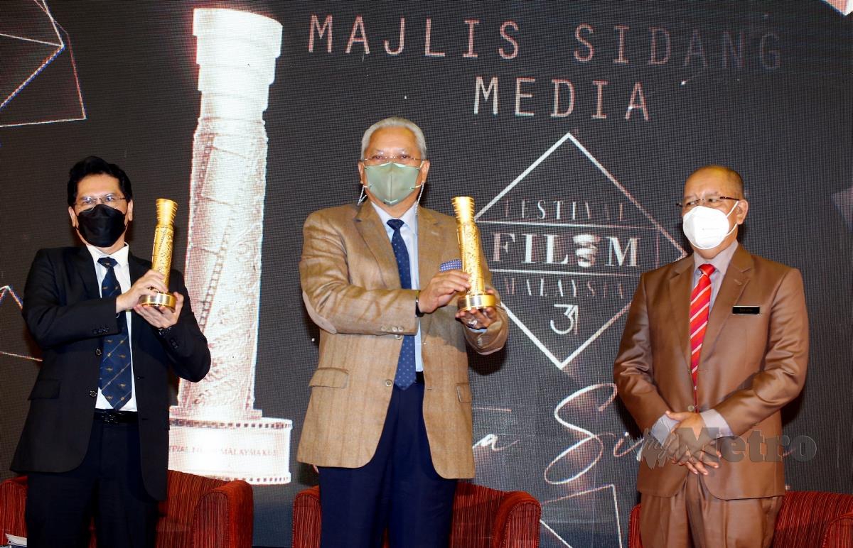 PETALING JAYA 01 DISEMBER 2021. Menteri Komunikasi dan Multimedia, Tan Sri Annuar Musa (tengah) menunjukkan trofi FFM31 yang dipertandingkan sambil diperhatikan Ketua Pegawai Eksekutif Finas, Prof Dr Md Nasir Ibrahim (kiri) dan Pengerusi Finas, Zakaria Abdul Hamid ketika sidang media Festival Filem Malaysia (FFM) ke-31 di Damansara. NSTP/HAIRUL ANUAR RAHIM