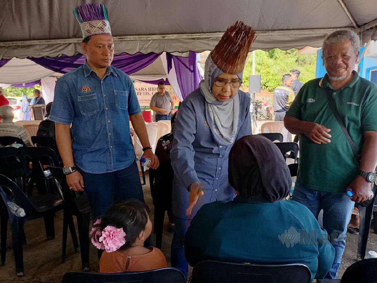 Ketua Pengarah JAKOA, Datuk Sapiah Dato Mohd Nor menyantuni penerima elaun sara hidup di (RPS) Kuala Betis, di sini. FOTO Paya Linda Yahya
