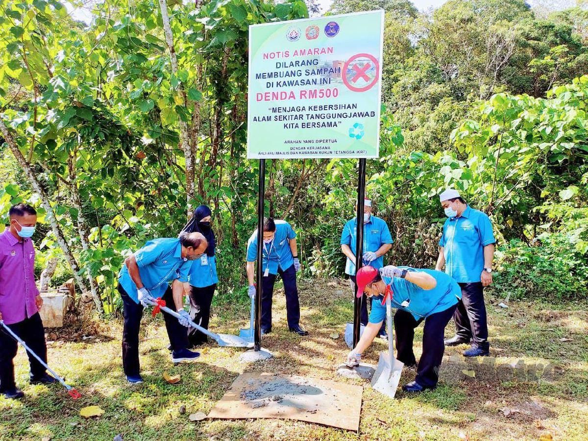 Setiausaha Majlis Daerah Tanjung Malim (MDTM), Roslan Kamaruzaman ( empat kiri) bersama komuniti setempat sedang memasang papan tanda larangan membuang sampah di Taman Sentosa, dekat sini,hari ini. FOTO Ihsan Pembaca