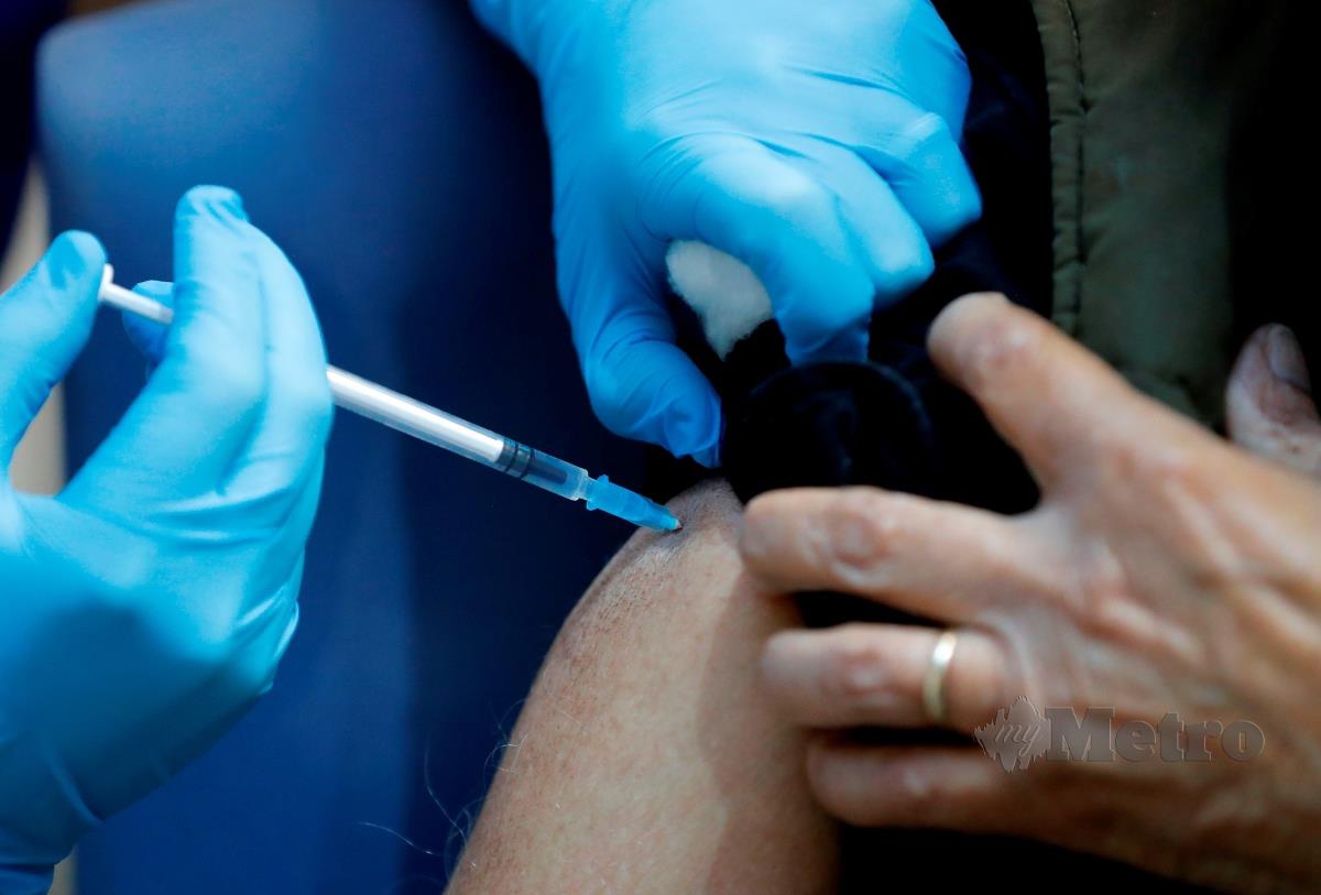 JURURAWAT menyuntik vaksin Covid-19 pada orang awam. FOTO AFP
