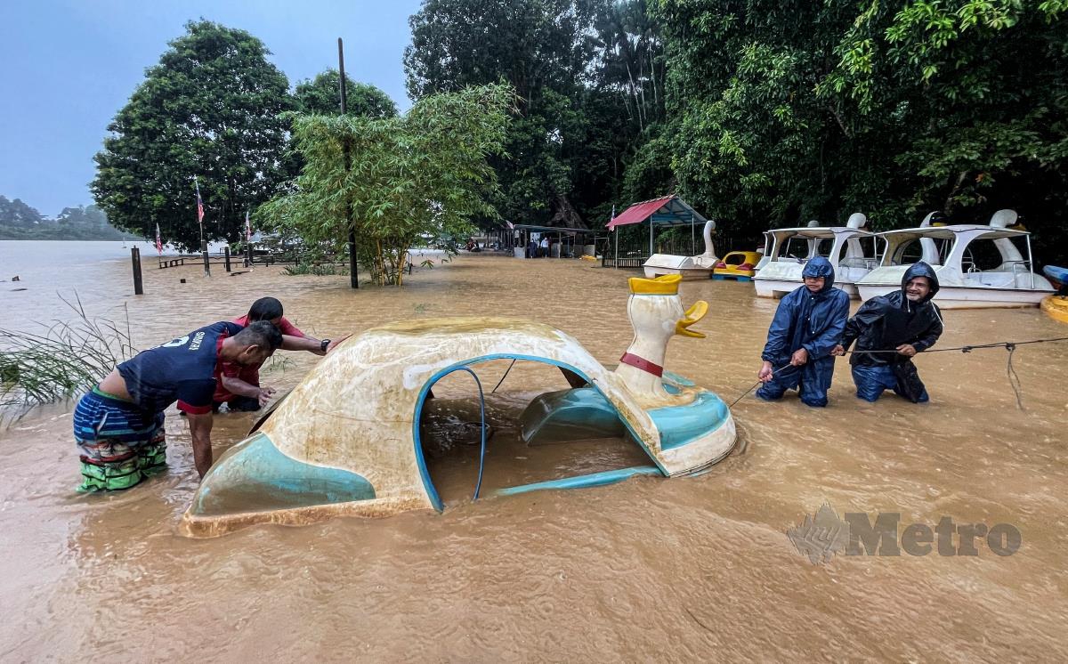 Penduduk mengalihkan bot itik ke tempat yang lebih selamat selepas hujan lebat  sejak malam tadı di Pusat Rekreasi Kalang Warisan. FOTO GHAZALI KORI