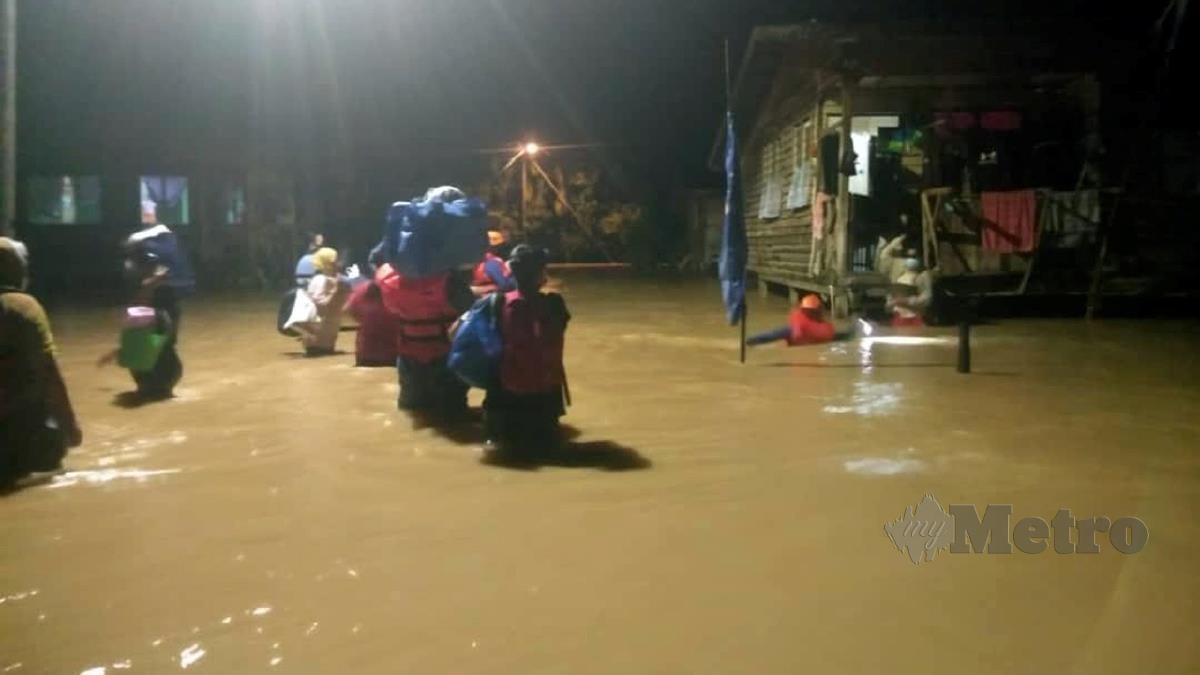 ANGGOTA keselamatan memindahkan penduduk terjejas banjir di beberapa kampung sekitar daerah Kota Marudu. FOTO ihsan APM