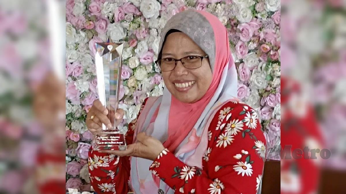 Dr Mahani Nordin menunjukkan anugerah Tun Dr Siti Hasmah yang diterima pada Majlis Gala Reben Merah Sunway - Yayasan AIDS Malaysia di Hotel Hilton kerana pembabitannya membantu pesakit HIV/AIDS. FOTO ZAID SALIM