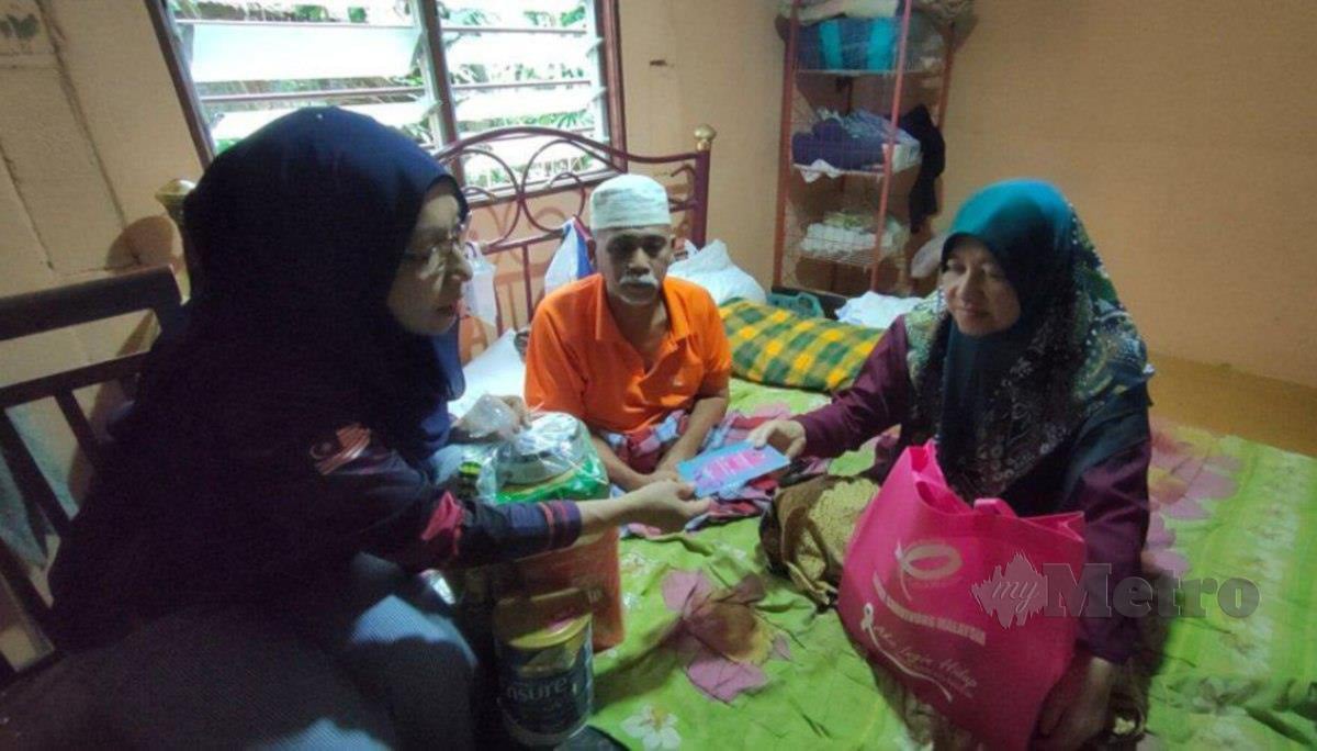 Pengerusi Cancer Survivors Malaysia (CSM), Zuraini Kamal (kiri) menyerahkan sumbangan wang tunai serta barangan keperluan dapur dan susu formula khas kepada Mahani Saleh yang menghidap kanser payu dara tahap tiga serta suaminya yang menghidap angin ahmar di rumah mereka di Kampung Chegar, Kuala Mawa. FOTO ZULIATY ZULKIFFLI
