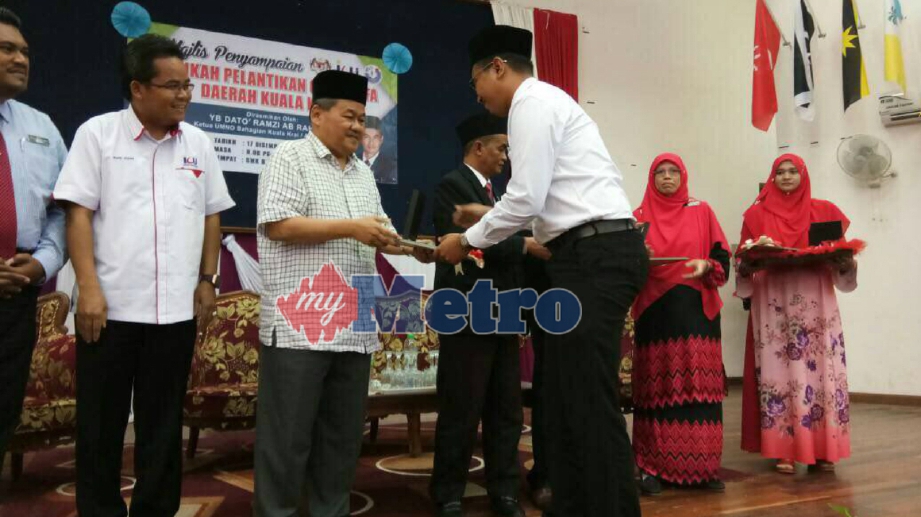 KETUA UMNO Bahagian Kuala Krai, Datuk Ramzi Abdul Rahman menyampaikan watikah pelantikan kepada guru KAFA, hari ini. FOTO Rohaida Omar
