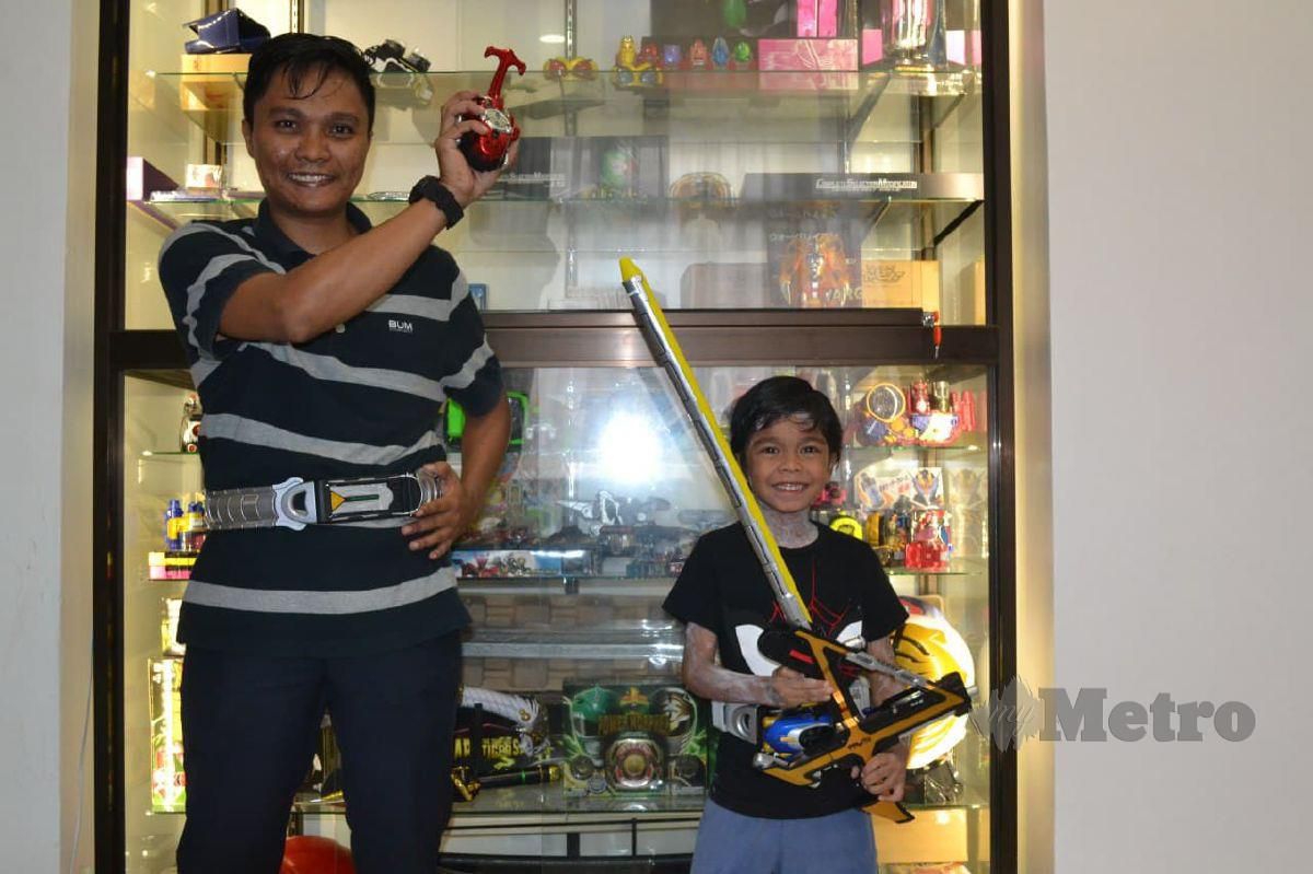 Muhamad Asyraf Rosli bersama anak, Muhammad Aisy Mikail menunjukkan koleksi tali pinggang Kamen Rider. FOTO Asrol Awang