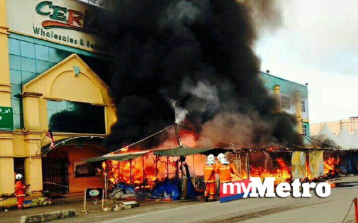 BOMBA berusaha memadamkan kebakaran empat gerai di Pasar Wakaf Che Yeh. FOTO ihsan Bomba