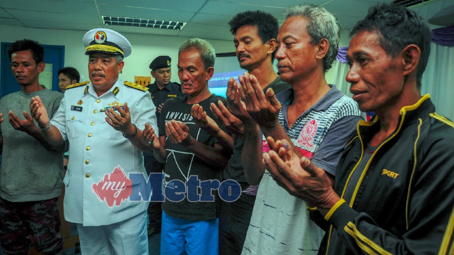 PENGARAH Maritim Daerah Kota Kinabalu, Laksamana Pertama Maritim, Adam Aziz (dua dari kiri) bersama mangsa bot hanyut yang berjaya diselamatkan membaca doa pada sidang media susulan kejadian bot pancing yang rosak di perairan Menggalum. FOTO Lano Lan
