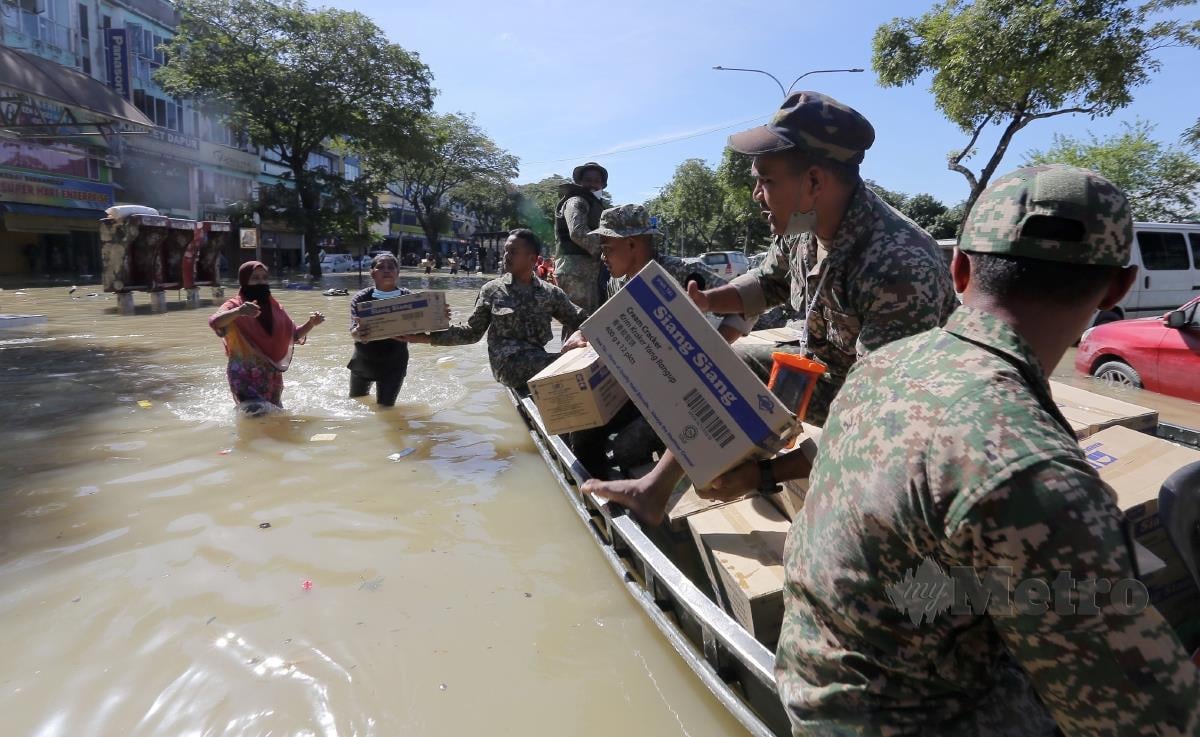 Anggota Tentera membantu menyalurkan bantuan kepada mangsa banjir Taman Sri Muda. FOTO OSMAN ADNAN