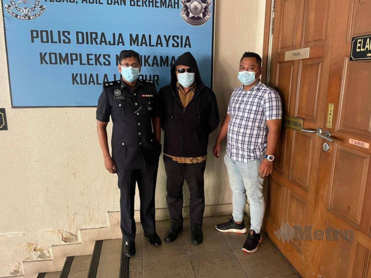 Mohd Rushdi Shafie, 59, (tengah) didakwa atas pertuduhan penipuan pelaburan mata wang kripto dikenali 'AliExchange' diiringi pegawai polis ketika dibawa ke Mahkamah Majistret Kuala Lumpur, hari ini. FOTO Ihsan PDRM