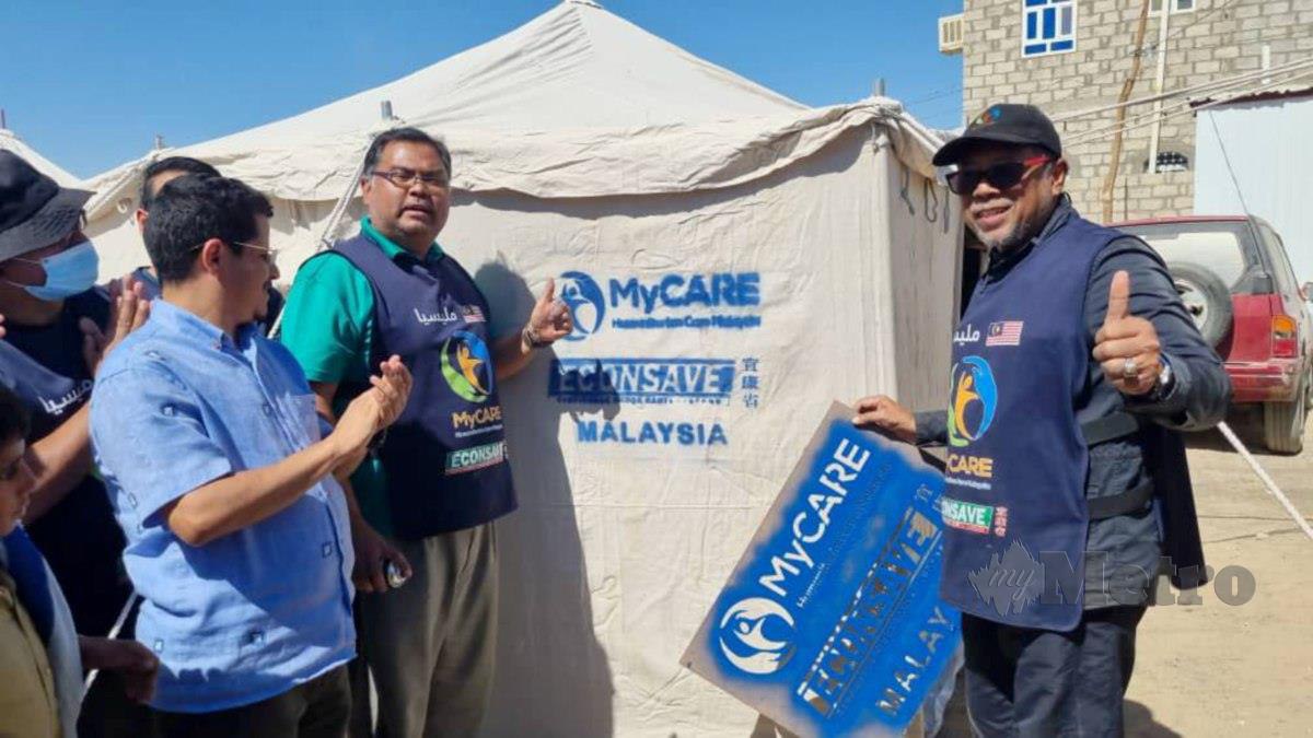 Dr Mohd Zin (kanan) dan Mas Imran (dua dari kiri) menyerahkan sebuah khemah baru kepada pelarian Yaman di Marib.