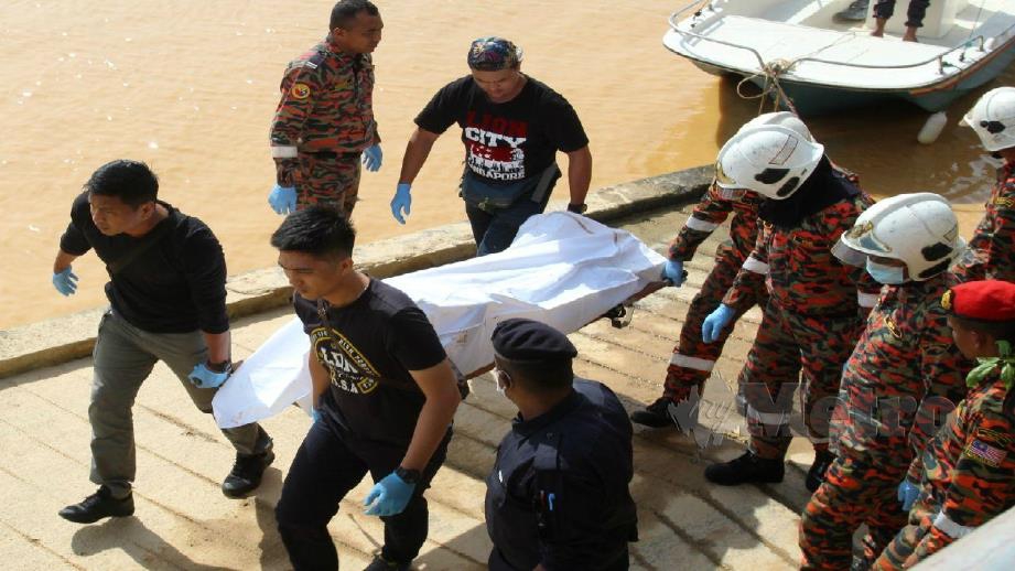 ANGGOTA polis dan bomba mengangkat mayat lelaki yang ditemui terapung di Sungai Kelantan. FOTO Abdullah Nik Omar